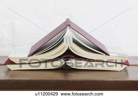 Open books stacked on wooden chest View Large Photo Image Stock Photo - Open books stacked on wooden chest. Fotosearch