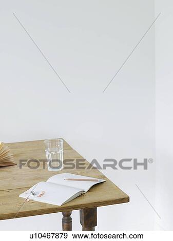 Open notebook and glass of water on table View Large Photo Image Stock Photo - Open notebook and glass of water on table. Fotosearch