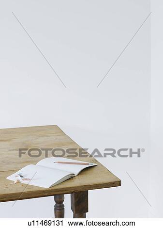 Stock Image - Open notebook with pencil and pencil sharpener on table elevated view. Fotosearch