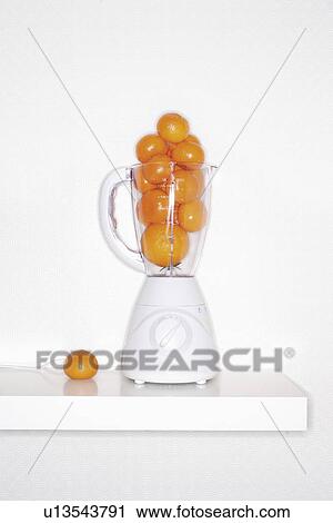 Stock Image - Orange fruits in blender. Fotosearch