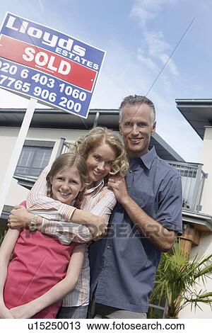 Parents and daughter (7-9) embracing outside new home portrait View Large Photo Image Stock Image - Parents and daughter (7-9) embracing outside new home portrait. Fotosearch