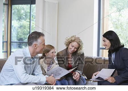Parents and daughter (7-9) with estate agent discussing new property View Large Photo Image Picture - Parents and daughter (7-9) with estate agent discussing new property. Fotosearch