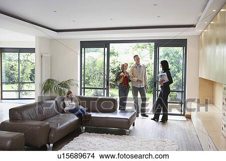 Parents with bored daughter (7-9) and estate agent observing new property View Large Photo Image Picture - Parents with bored daughter (7-9) and estate agent observing new property. Fotosearch