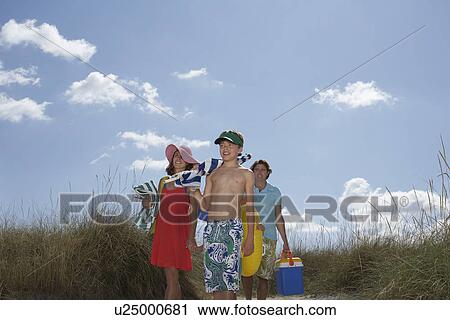 Parents with son (10-12) carrying beach accessories View Large Photo Image Stock Image - Parents with son (10-12) carrying beach accessories. Fotosearch