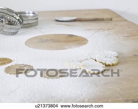 Picture - Pastry cutters cookies and flour scattered on table close up. Fotosearch