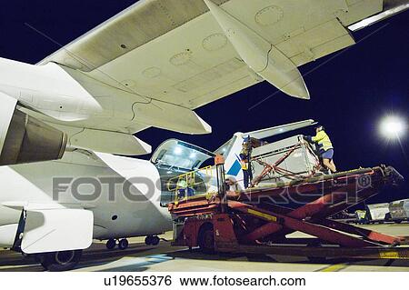 Stock Photograph - People loading aeroplane at airport. Fotosearch