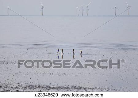 People running on beach wind farm in distance View Large Photo Image Stock Photo - People running on beach wind farm in distance. Fotosearch