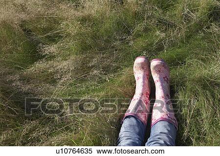 Person wearing pink galoshes lying in grass low section View Large Photo Image Stock Photography - Person wearing pink galoshes lying in grass low section. Fotosearch