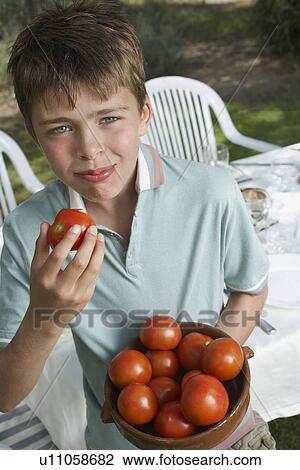 Portrait of boy (10-12) with bowl of tomatoes near table in garden View Large Photo Image Stock Image - Portrait of boy (10-12) with bowl of tomatoes near table in garden. Fotosearch