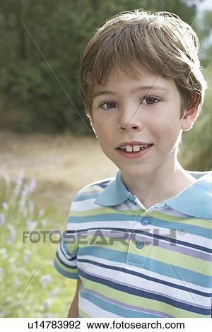 Stock Image - Portrait of boy (5-6) in striped polo t-shirt. Fotosearch