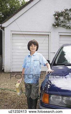 Portrait of boy (7-9) posing by washed car View Large Photo Image Stock Image - Portrait of boy (7-9) posing by washed car. Fotosearch