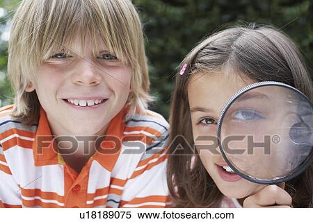 Portrait of boy and girl (7-9) girl holding magnifying glass View Large Photo Image Stock Photography - Portrait of boy and girl (7-9) girl holding magnifying glass. Fotosearch