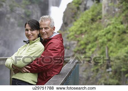 Stock Photo - Portrait of couple posing by railing in mountains. Fotosearch