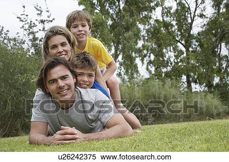 Portrait of couple with two sons (6-11) lying on top of each other on lawn View Large Photo Image Stock Photography - Portrait of couple with two sons (6-11) lying on top of each other on lawn. Fotosearch