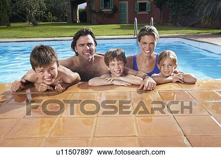 Portrait of family with three children (5-11) in swimming pool smiling View Large Photo Image Stock Photo - Portrait of family with three children (5-11) in swimming pool smiling. Fotosearch