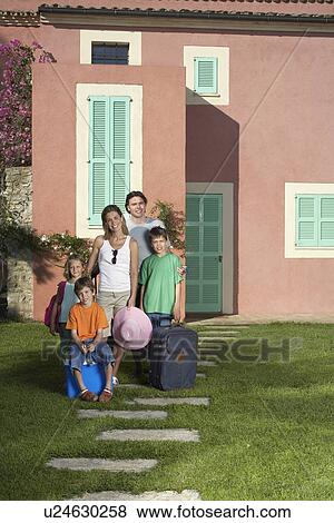 Portrait of family with three children (6-11) with luggage in front of house View Large Photo Image Stock Photo - Portrait of family with three children (6-11) with luggage in front of house. Fotosearch
