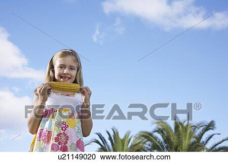Stock Image - Portrait of girl (5-6) eating corn on the cob. Fotosearch