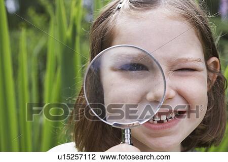 Portrait of girl (7-9) looking through magnifying glass View Large Photo Image Stock Image - Portrait of girl (7-9) looking through magnifying glass. Fotosearch