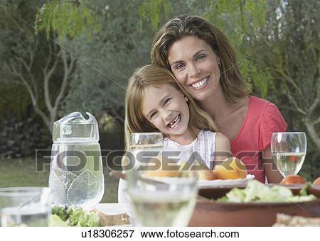 Portrait of mother and daughter (5-6) at garden table View Large Photo Image Stock Photo - Portrait of mother and daughter (5-6) at garden table. Fotosearch