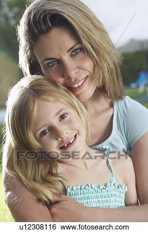 Portrait of mother and daughter (5-6) hugging and smiling View Large Photo Image Stock Photograph - Portrait of mother and daughter (5-6) hugging and smiling. Fotosearch
