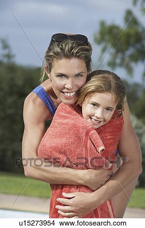 Picture - Portrait of mother embracing daughter (5-6) wrapped in towel. Fotosearch