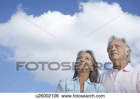 Portrait of senior couple against sky looking up View Large Photo Image Stock Photograph - Portrait of senior couple against sky looking up. Fotosearch