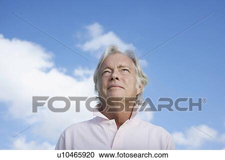 Stock Image - Portrait of senior man against sky. Fotosearch