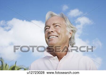 Stock Photo - Portrait of senior man against sky smiling. Fotosearch