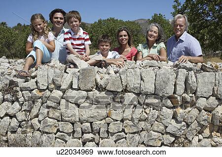 Portrait of three-generation family with three children (6-11) by stone wall View Large Photo Image Stock Photo - Portrait of three-generation family with three children (6-11) by stone wall. Fotosearch