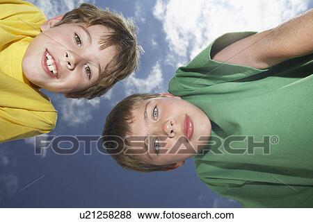 Portrait of two boys (6-11) bending down view from below View Large Photo Image Stock Photo - Portrait of two boys (6-11) bending down view from below. Fotosearch