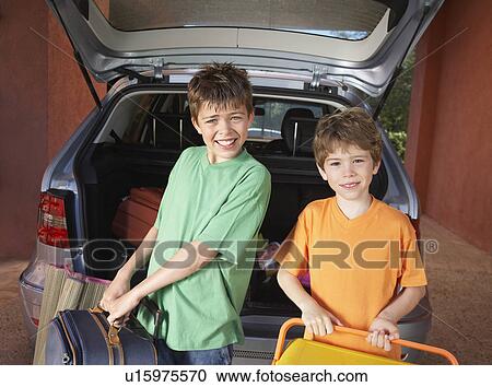 Portrait of two boys (6-11) carrying suitcases in front of car View Large Photo Image Stock Image - Portrait of two boys (6-11) carrying suitcases in front of car. Fotosearch