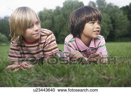 Portrait of two boys (7-9) lying in meadow looking away View Large Photo Image Stock Image - Portrait of two boys (7-9) lying in meadow looking away. Fotosearch
