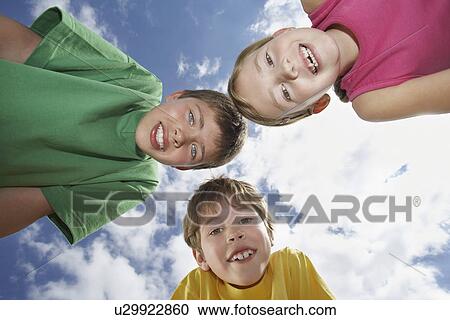 Portrait of two boys and girl (6-11) bending down view from below View Large Photo Image Stock Image - Portrait of two boys and girl (6-11) bending down view from below. Fotosearch
