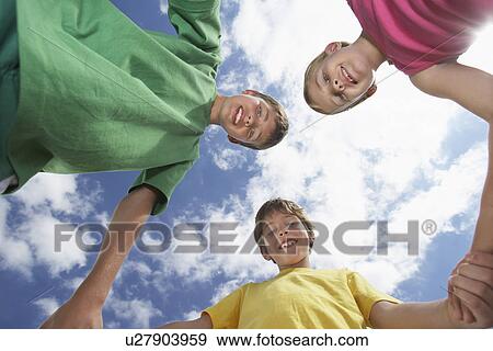 Portrait of two boys and girl (6-11) holding hands view from below View Large Photo Image Stock Photo - Portrait of two boys and girl (6-11) holding hands view from below. Fotosearch