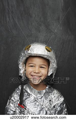 Stock Photo - Portrait of young boy (5-6) in aluminum foil astronaut costume smiling studio shot. Fotosearch