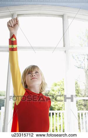 Portrait of young boy (7-9) in superhero costume with raised fist looking up View Large Photo Image Stock Image - Portrait of young boy (7-9) in superhero costume with raised fist looking up. Fotosearch