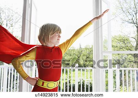 Portrait of young boy (7-9) wearing superhero costume arm raised indoors View Large Photo Image Stock Photography - Portrait of young boy (7-9) wearing superhero costume arm raised indoors. Fotosearch