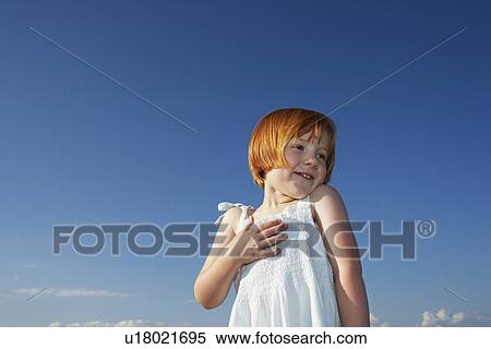 Portrait of young girl (5-6) against blue sky View Large Photo Image Stock Photography - Portrait of young girl (5-6) against blue sky. Fotosearch