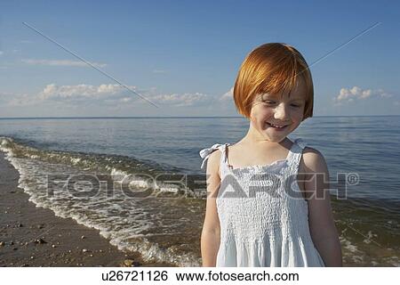 Portrait of young girl (5-6) at ocean smiling View Large Photo Image Stock Photograph - Portrait of young girl (5-6) at ocean smiling. Fotosearch