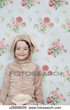 Portrait of young girl (5-6) in bunny costume against wallpaper with floral pattern View Large Photo Image Stock Photo - Portrait of young girl (5-6) in bunny costume against wallpaper with floral pattern. Fotosearch