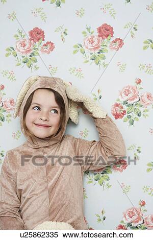 Portrait of young girl (5-6) in bunny costume touching ear wallpaper with floral pattern in background View Large Photo Image Stock Photography - Portrait of young girl (5-6) in bunny costume touching ear wallpaper with floral pattern in background. Fotosearch
