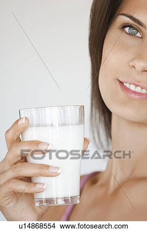 Picture - Portrait of young woman holding glass of milk. Fotosearch