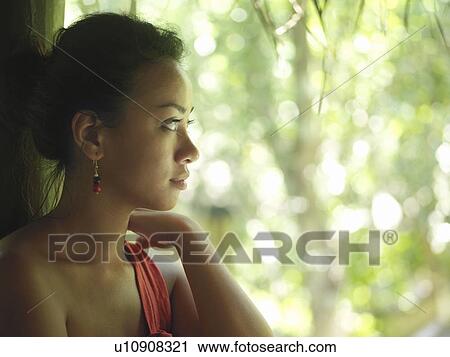 Stock Image - Portrait of young woman looking at trees profile. Fotosearch