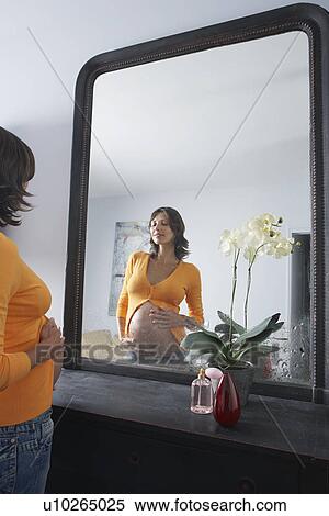 Pregnant woman admiring stomach in bedroom mirror View Large Photo Image Stock Photography - Pregnant woman admiring stomach in bedroom mirror. Fotosearch