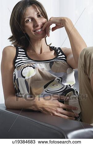 Pregnant woman sitting in armchair indoors View Large Photo Image Stock Image - Pregnant woman sitting in armchair indoors. Fotosearch