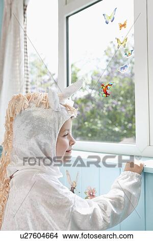 Profile of young girl (5-6) in unicorn costume opening door smiling View Large Photo Image Picture - Profile of young girl (5-6) in unicorn costume opening door smiling. Fotosearch