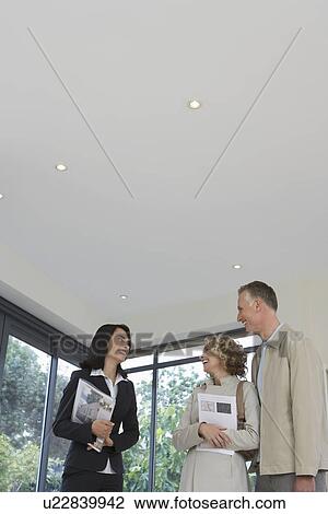 Real estate agent and couple observing new property View Large Photo Image Stock Image - Real estate agent and couple observing new property. Fotosearch