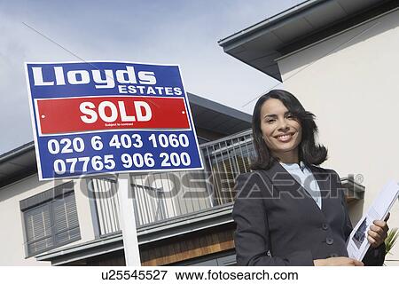 Real estate agent beside sold sign outside house portrait View Large Photo Image Stock Photo - Real estate agent beside sold sign outside house portrait. Fotosearch