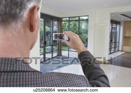 Picture - Real estate agent photographing new property. Fotosearch