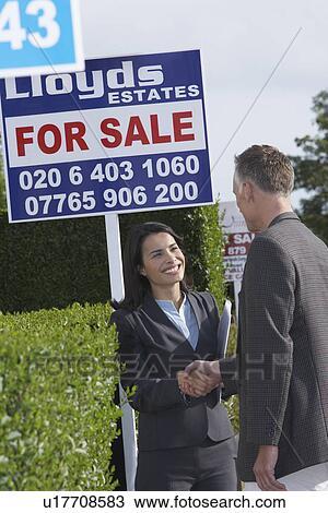 Real estate agent shaking hands with man beside for sale signs View Large Photo Image Stock Image - Real estate agent shaking hands with man beside for sale signs. Fotosearch